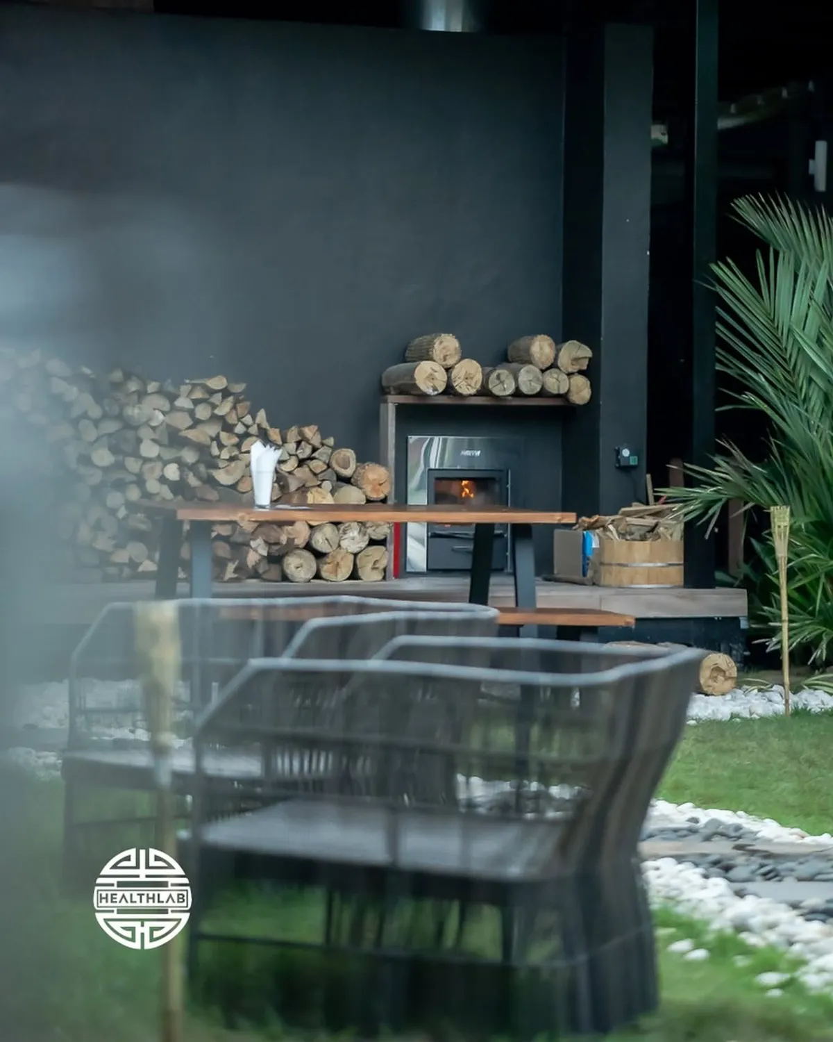 Outdoor lounge area with wood-fired oven at The Healthlab